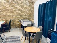 Fonfa Liget في Sénye: غرفة مع طاولة وكراسي وجدار من الطوب