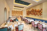 um restaurante com mesas e cadeiras em uma sala em Pilibhit House, Haridwar – IHCL SeleQtions em Haridwār