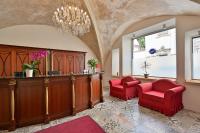 a large room with two red chairs and a bar at Hotel Garden Court in Prague
