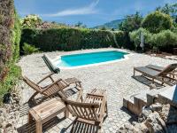 a patio with chairs and a swimming pool at Holiday home in La Roquette sur Siane with furnished garden in La Roquette-sur-Siagne