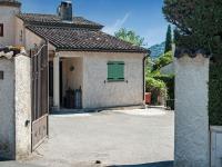 a house with a green door in a driveway at Holiday home in La Roquette sur Siane with furnished garden in La Roquette-sur-Siagne