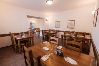 uma sala de jantar com mesas e cadeiras de madeira em Hotel Pod Zámkem em Vranov nad Dyjí