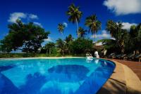 a swimming pool with blue water and palm trees at Sarikantang Resort & Spa, Koh Phangan in Haad Rin