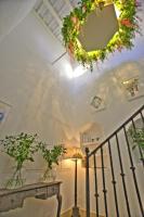a staircase with a wreath on the ceiling and a lamp at La Casa de la Favorita in Tarifa