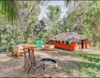 uma casa com uma mesa e cadeiras e uma fogueira em Coorg amodhini em Madikeri