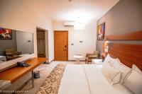 Una habitación de hotel con una cama y una sala de estar. en Charleson Luxury Hotel, en Port Harcourt