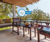 a patio with a table and chairs and a sign at Sarikantang Resort & Spa, Koh Phangan in Haad Rin