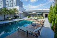 Una piscina con mesas y sillas al lado de un edificio. en Hotel Florença, en Americana