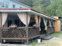 a house with a porch with curtains and flowers at Kuru Guest House in Kuru