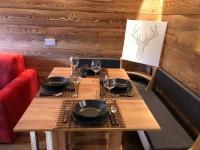 Una mesa de madera con platos y copas de vino encima. en Les Marmottes, en Breuil-Cervinia