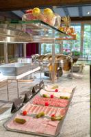 ein Buffet mit Fleisch und Gemüse auf dem Tisch in der Unterkunft Arca Aparthotel &amp; Spa in Zermatt