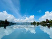 a pool of water with a blue sky and clouds at Ailiga Travel Villa in Ren&#39;ai