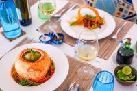 a table with two plates of food and glasses of wine at Casa Paradis Boutique Hotel in Jambiani