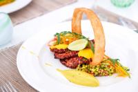 a plate of food with meat and vegetables on a table at Casa Paradis Boutique Hotel in Jambiani
