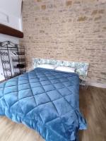 a blue bed in a room with a brick wall at Appartement Oingt - Les Meublés des Pierres Dorées in Theizé