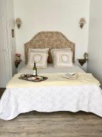a bed with a bottle of wine and a tray with a bottle of champagne at LE VIEUX MOULIN in Bouhet