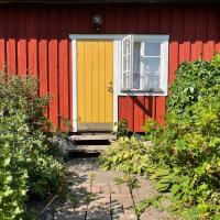 a red house with a yellow door and a window at Klefstad Gård in Linghem