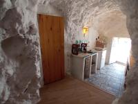 a kitchen with a stone wall and a door at Casa Cueva “La Estrella” in Granada