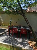 a table and two chairs under a tree at Le cottage de l&#39;étang in Le Tablier