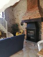 a living room with a fireplace and a blue couch at Le cottage de l&#39;étang in Le Tablier