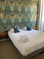 a bedroom with a large white bed with a wallpaper at Grand Hotel De La Poste - Lyon Sud - Vienne in Vienne