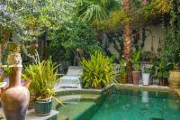 un jardín con una piscina con macetas en Dar Souad, en La Marsa