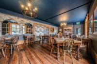 Un comedor con mesas y sillas de madera. en The Ship At Dunwich, en Dunwich
