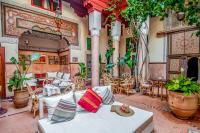 a dining room with tables and chairs and plants at Riad Chorfa in Marrakesh