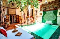 a large swimming pool in a room with a table at Riad Chorfa in Marrakesh