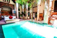 a large swimming pool in a building with a couch at Riad Chorfa in Marrakesh