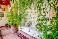 a white couch sitting on a patio with plants at Riad Chorfa in Marrakesh