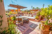 a patio with a table and an umbrella on a roof at Riad Chorfa in Marrakesh