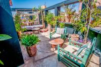 a patio with chairs and a table and potted plants at Riad Chorfa in Marrakesh