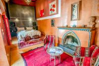 a living room with a fireplace and a bed at Riad Chorfa in Marrakesh