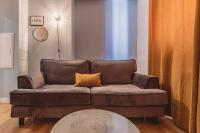 ein braunes Sofa im Wohnzimmer mit einem Tisch in der Unterkunft Reims - City Center - Cathédrale - FORUM in Reims