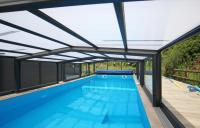 a large swimming pool with an open roof at Gîte De L&#39;Etot Fossey in Marchésieux