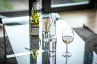 a glass table with two glasses and a bottle of wine at City View Apartments Birmingham City Centre in Birmingham