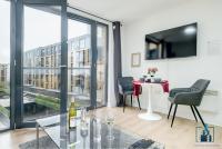 a living room with a table and chairs and a tv at City View Apartments Birmingham City Centre in Birmingham