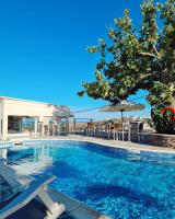 una piscina con sillas y sombrillas en Petali Village Hotel, en Apollonia