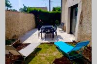 a patio with chairs and a table and a table and chairs at MAISON RESTAUREE 6 PERSONNES AU COEUR DU PERIGORD in Sourzac