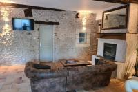 a living room with a couch and a fireplace at MAISON RESTAUREE 6 PERSONNES AU COEUR DU PERIGORD in Sourzac