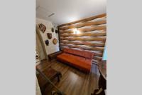 a brown couch in a room with a wooden wall at MAISON RESTAUREE 6 PERSONNES AU COEUR DU PERIGORD in Sourzac