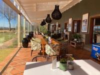 un ristorante con patio arredato con tavoli e sedie di Gowrie Farm Golf Lodge a Nottingham Road