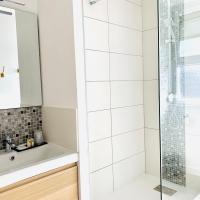 a white bathroom with a shower and a sink at Hôtel Jules in Le Touquet-Paris-Plage