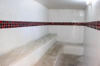 a white tiled bathroom with red and white tiles at Pousada Boulevard in Cabo Frio