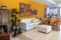 a living room with a white couch and two chairs at Pousada Boulevard in Cabo Frio