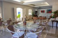 a room with tables and chairs and a living room at Pousada Boulevard in Cabo Frio