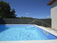 a swimming pool with blue water in front of a fence at Holiday Home Milka 1 - ROJ315 by Interhome in Svetvinčenat