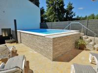 a swimming pool with chairs and a brick wall at Holiday Home Milka 1 - ROJ315 by Interhome in Svetvinčenat