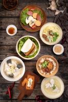 a group of plates of food on a wooden table at Taipung Suites in Anping